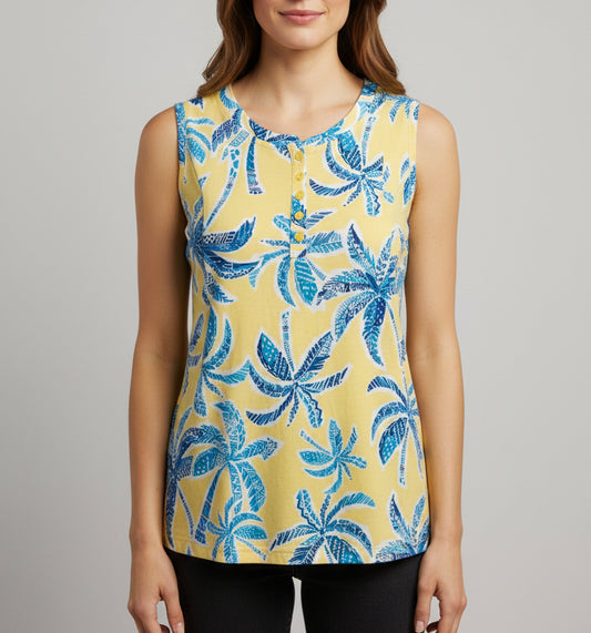 Yellow shirt with blue palm tree pattern on a beige surface