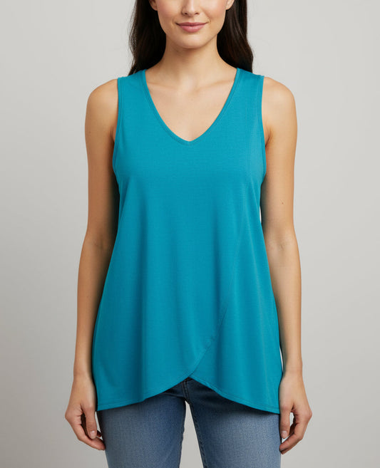 Woman wearing a teal sleeveless top against a gray background