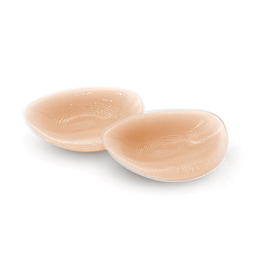 Two beige silicone breast pads on a white background