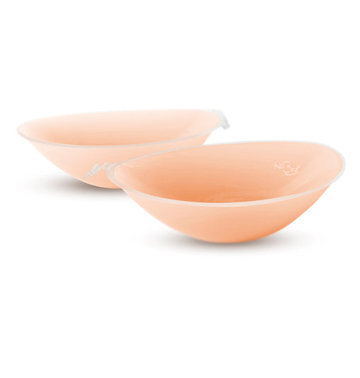 Two peach-colored silicone breast forms on a white background