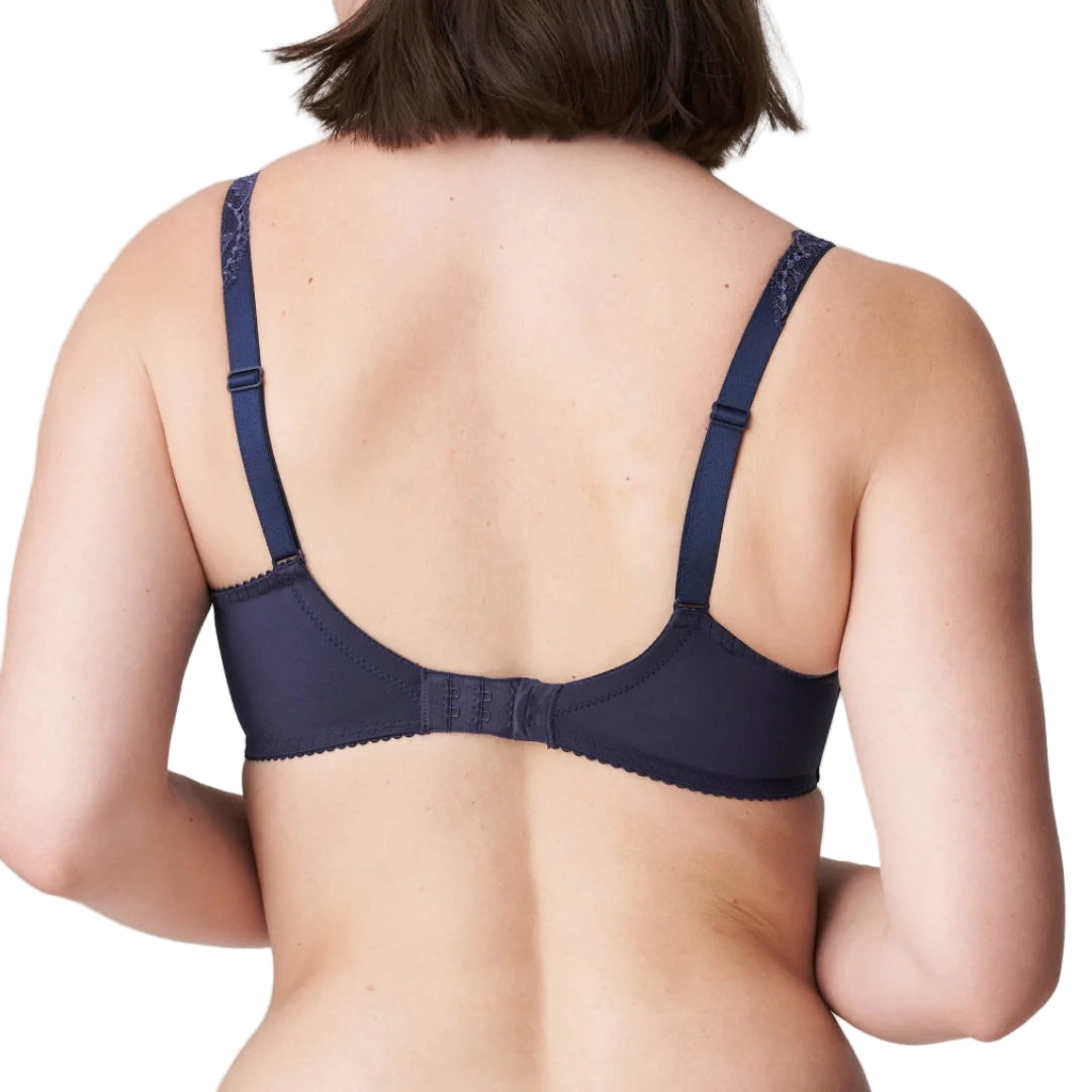 Navy blue bra worn by a person on a light gray background