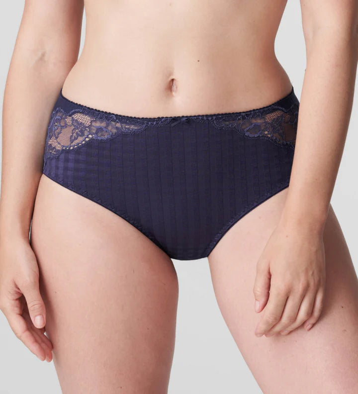 Navy blue lace-trimmed underwear worn by a person on a light gray background