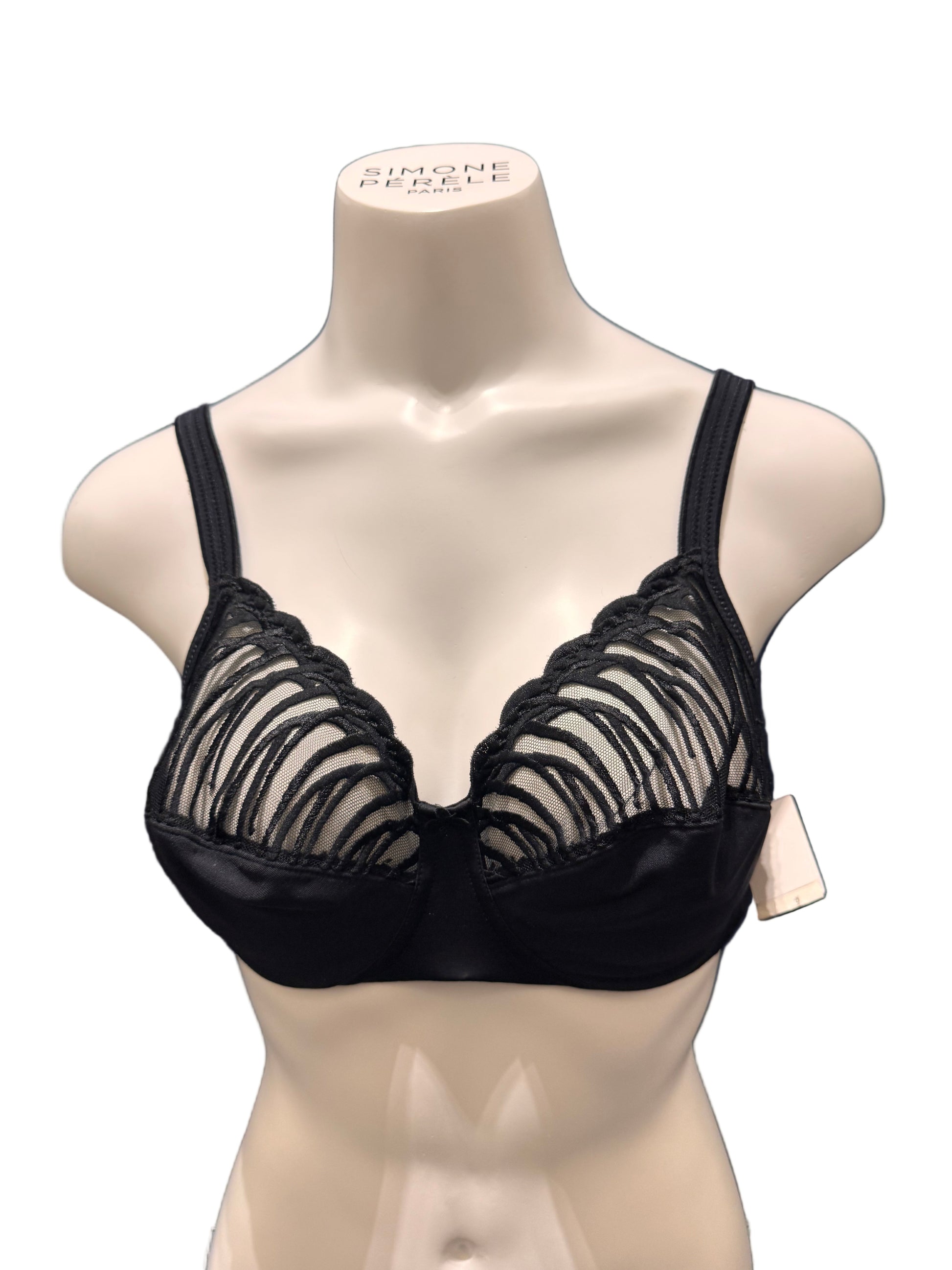 Black lace lingerie on a mannequin against a dark blue background