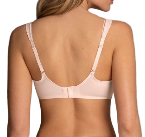 Woman wearing a beige bra against a gray background