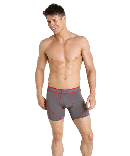 Man wearing gray boxer briefs with red waistband on a white background