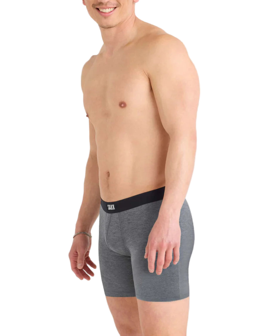 Man wearing gray boxer briefs with a black waistband on a white background