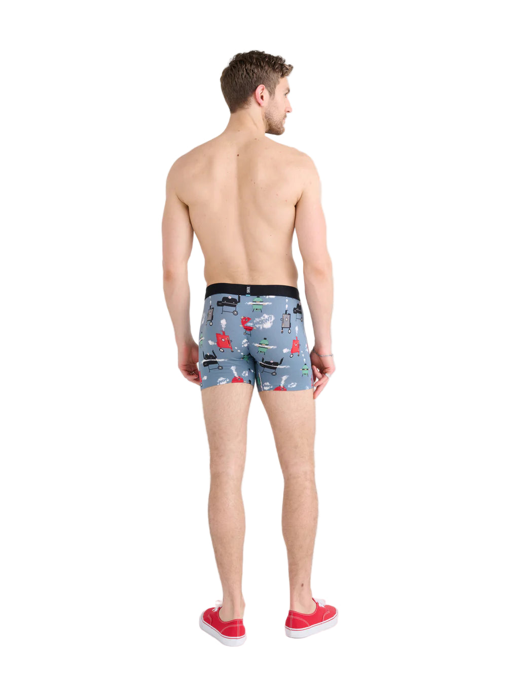Man wearing patterned swim shorts on a white background