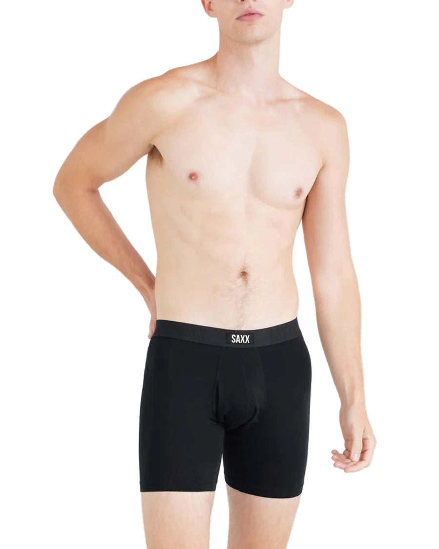 Person wearing black boxer briefs with a visible saxx logo 