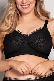 Woman wearing a black lace bra against a plain background
