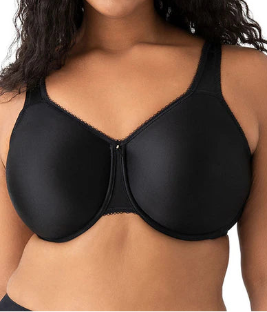 Woman wearing a black bra against a white background