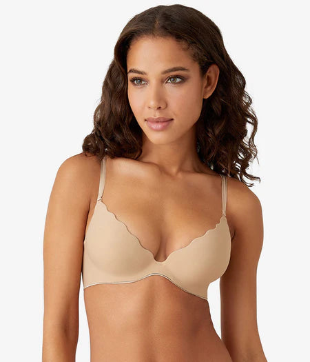 Woman wearing a beige bra against a plain background