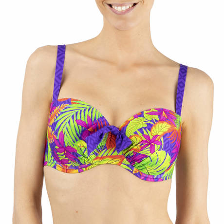 Woman wearing a colorful tropical leaf pattern bikini top on a white background