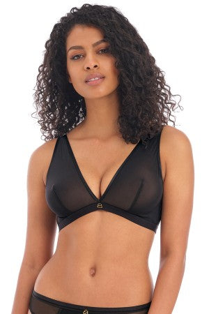 Woman wearing a black sheer bralette on a white background