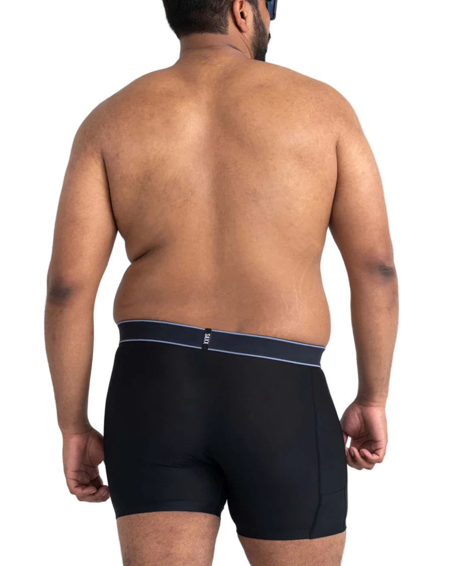 Man wearing black swim briefs with a white background